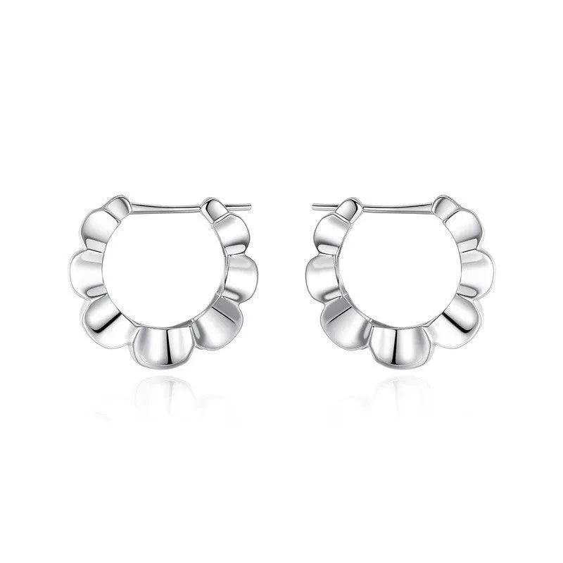 A pair of round, polished sterling silver geometric stud earrings on a plain background.