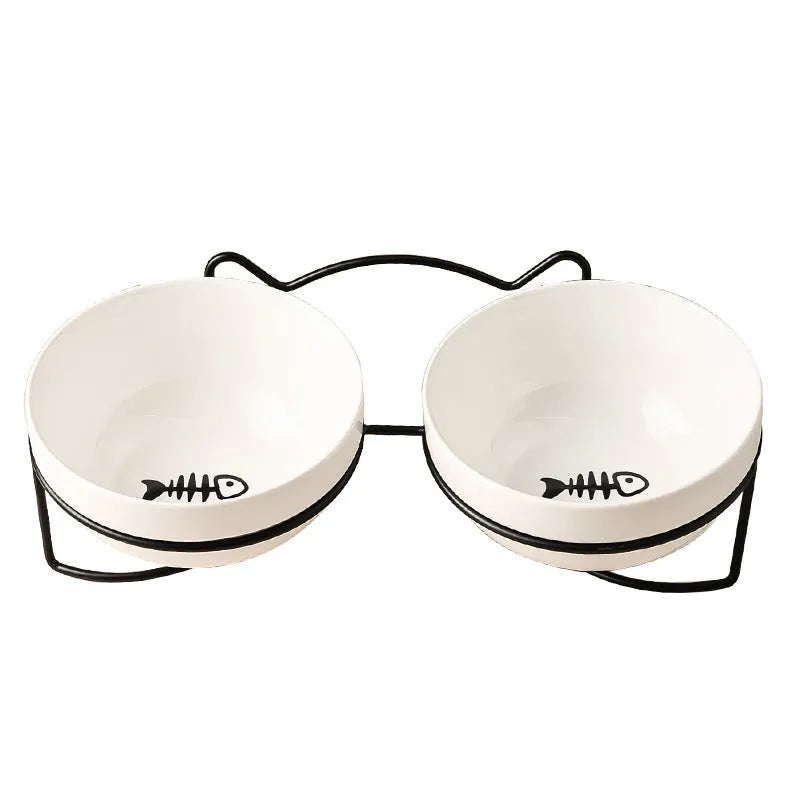 White ceramic pet bowl with cat paw design on a black iron frame raised feeder.