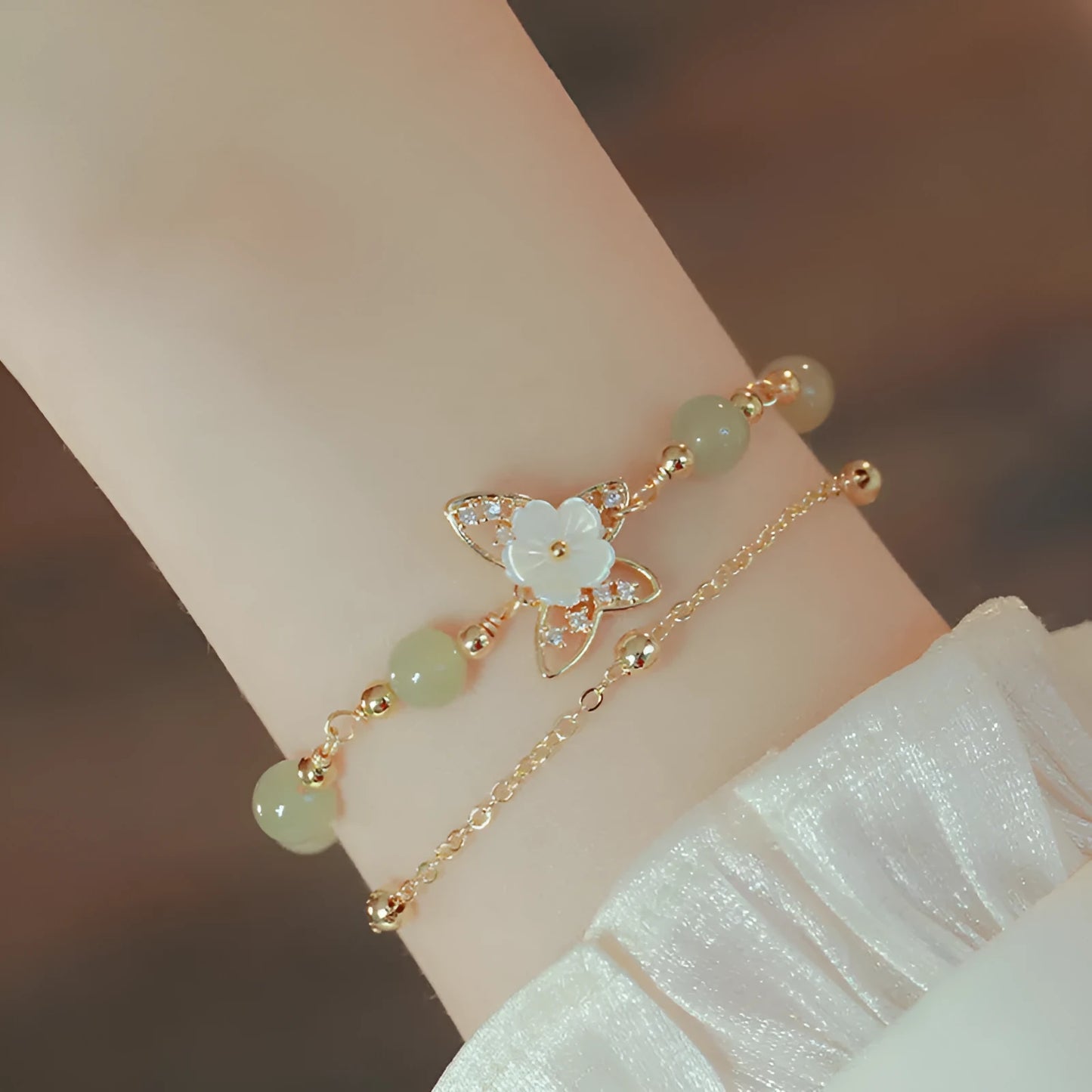 Women's shell flower butterfly bracelet in yellow gold with geometric design and hetian jade style charm.