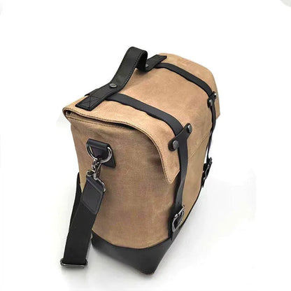 Black waterproof canvas motorcycle side bag with cowhide accents showing mounting straps