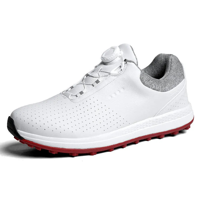 Men's white and black casual golf shoes with perforated upper and low-top design on a grass surface.