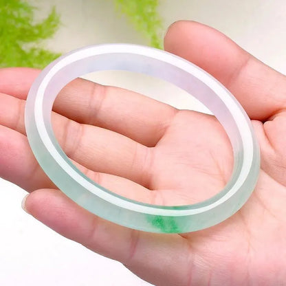 Jade bracelet with floating flower patterns and auspicious cloud motifs in green stone with polished finish