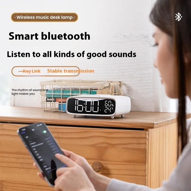 White Bluetooth speaker wireless charger with night lamp functions on wooden surface