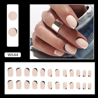 Set of 24 black and white frosted French tip fake nails with matte finish, laid out in size order.
