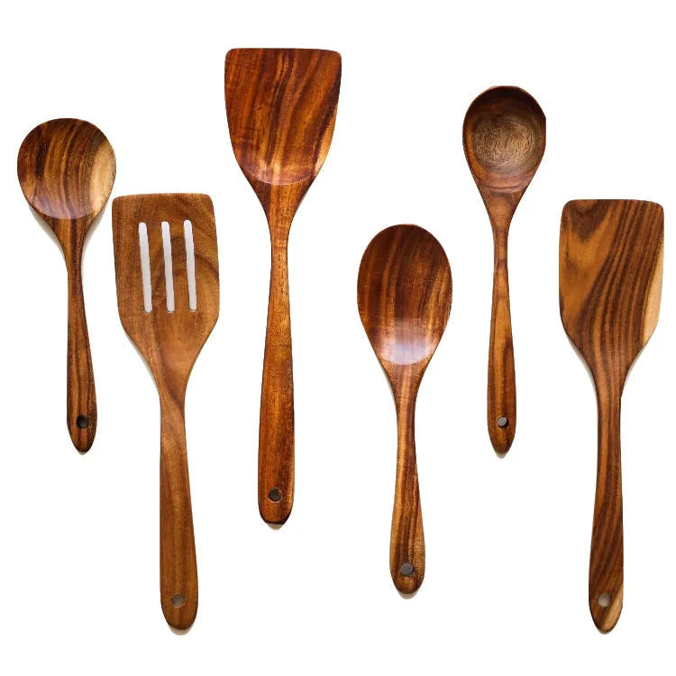 Set of seven light brown wooden cooking utensils including spoons, spatula, and turner on a kitchen counter.