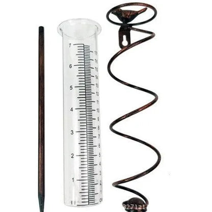 Cast iron hummingbird-shaped rain gauge with glass measurement tube showing 1-20 scale markings