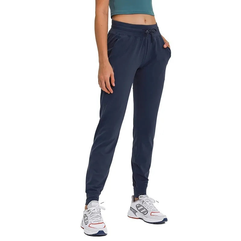 Women's high waist yoga pants with drawstring waistband in Belgian blue colour, showing stretch fabric during yoga pose