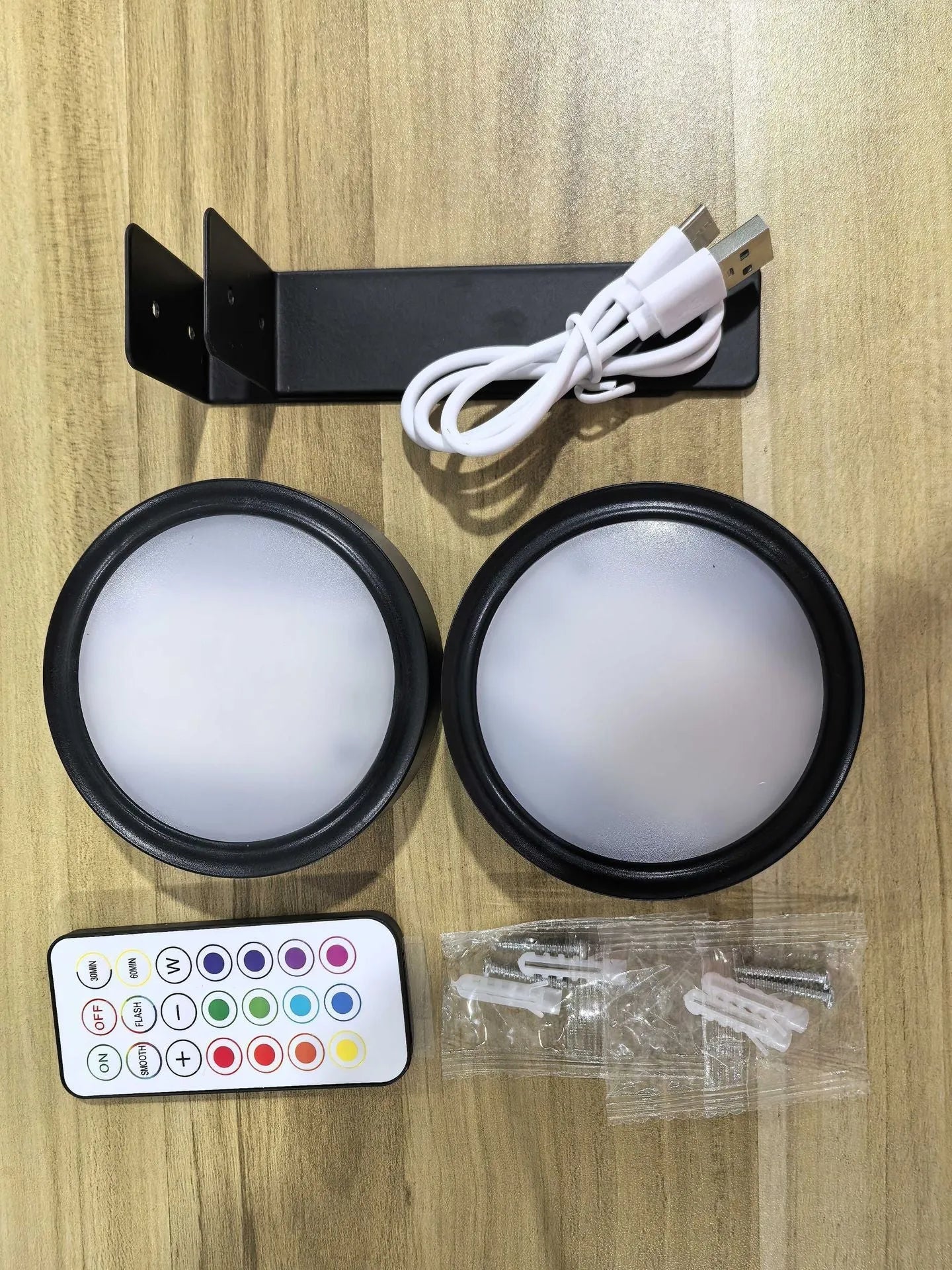 Black magnetic LED painting lamp with remote control on a white wall.