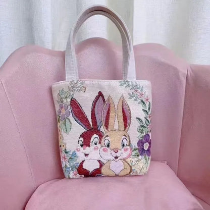 Colourful embroidered canvas shoulder bag with gold wire handles shown in small, medium, and large sizes.