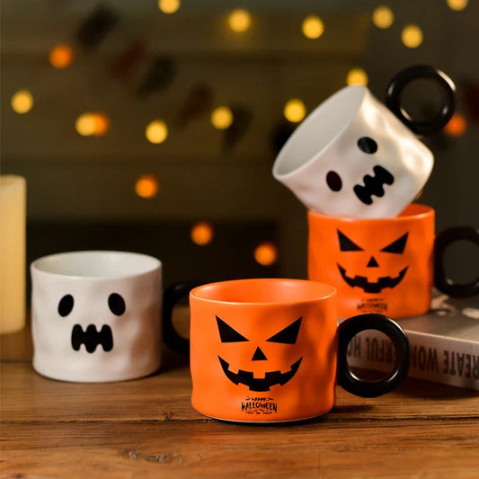 Ceramic pumpkin-shaped mugs in orange and white colors, featuring a sturdy handle and festive holiday design