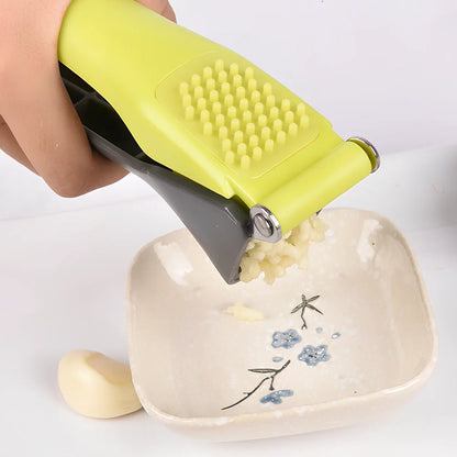 White plastic garlic masher with stainless steel crushing grid and ergonomic handle for kitchen use