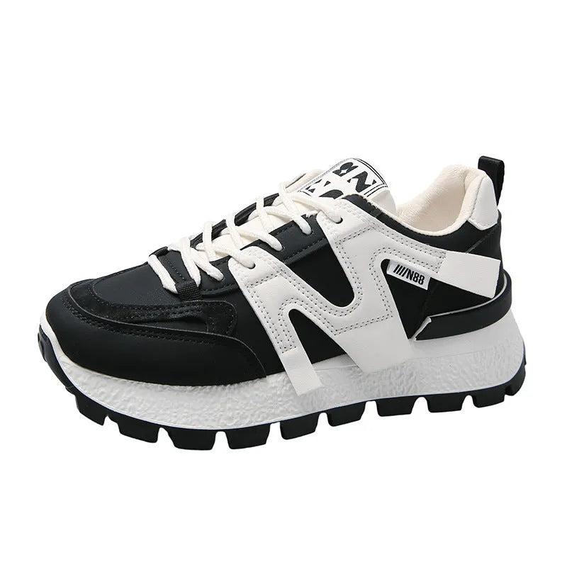 White low-top unisex sneaker with round toe and flat rubber sole on a plain background.