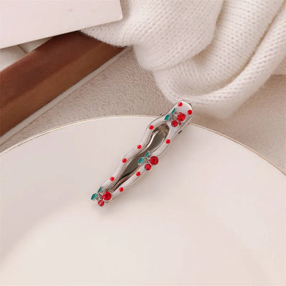 Red plastic hair clip with a 3D love heart and dots on a willow leaf-shaped base.