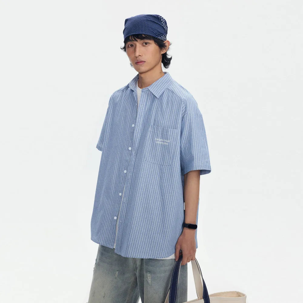 Blue and white striped loose-fitting short-sleeved overalls shirt on a hanger.