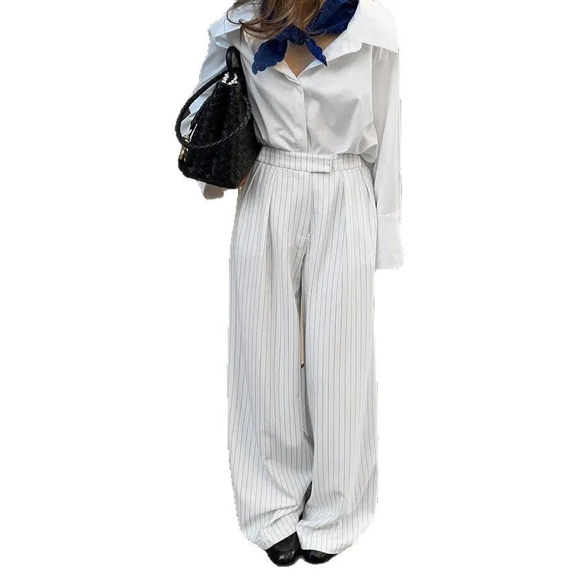 White striped wide-leg casual trousers with a front zipper on a hanger.