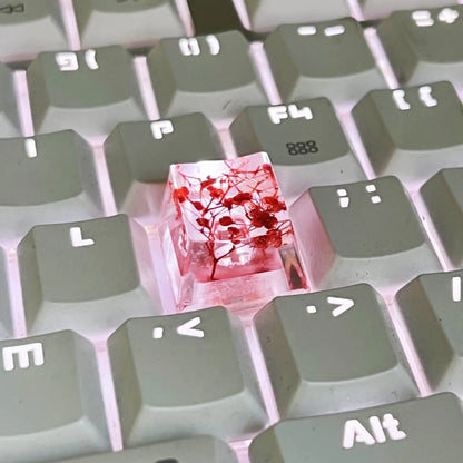 A transparent resin keycap with a starry sky design inside, shown in a green colour variant.
