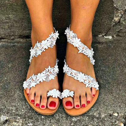 White women's flat shoes with rhinestone and floral embellishments on a patent leather PU upper, showing round toe and low back design.