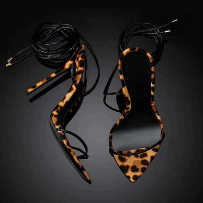 Women's leopard print pointed toe Roman sandals with a lace-up front and buckle.