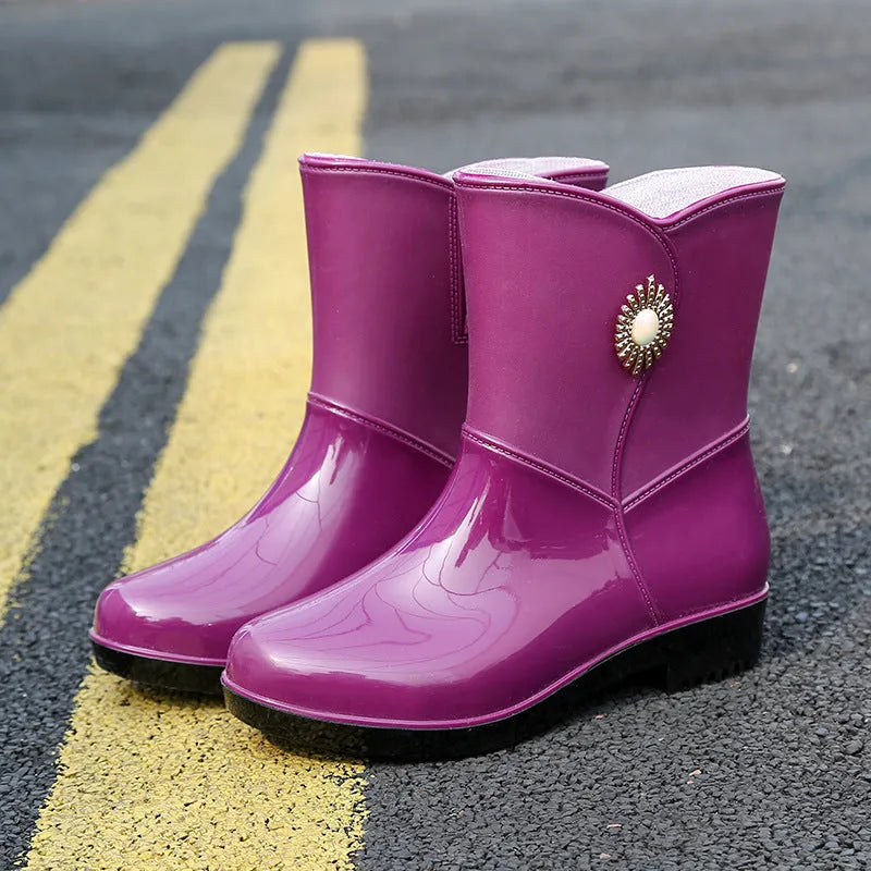 Women's purple PVC rain boot with non-slip sole on a wet surface.