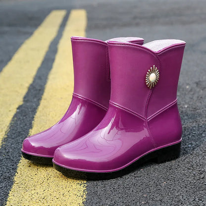 Women's purple PVC rain boot with non-slip sole on a wet surface.