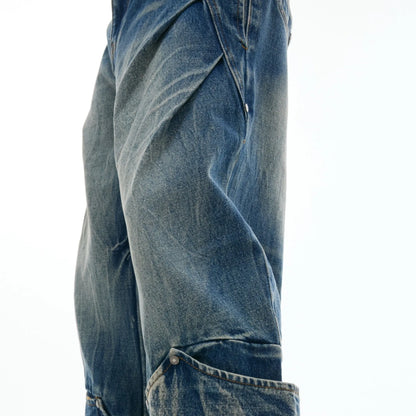 Men's verdant blue jeans with washed burst pattern and curved knife design, showing loose fit and retro style.