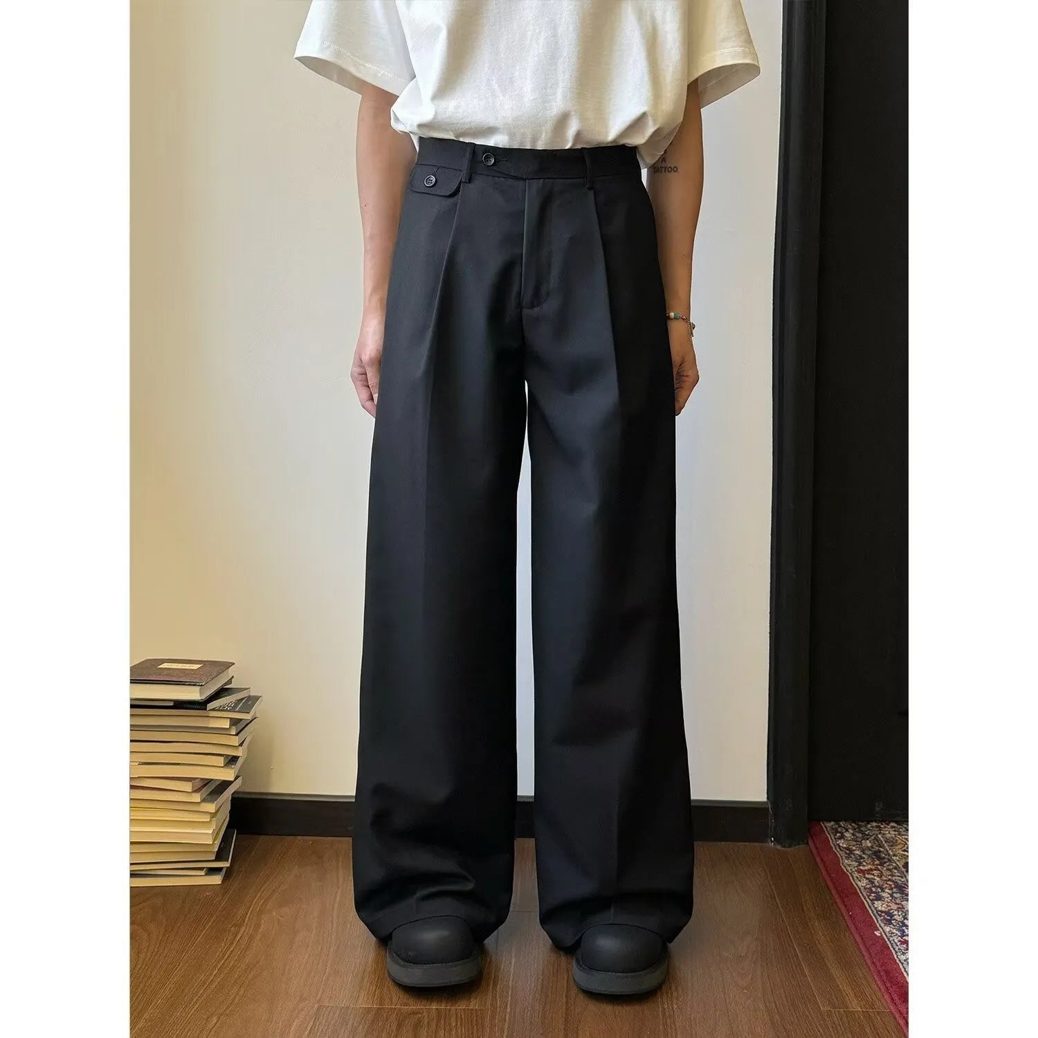 Men's brown straight-leg casual trousers with a relaxed drape and wide-leg silhouette on a hanger.
