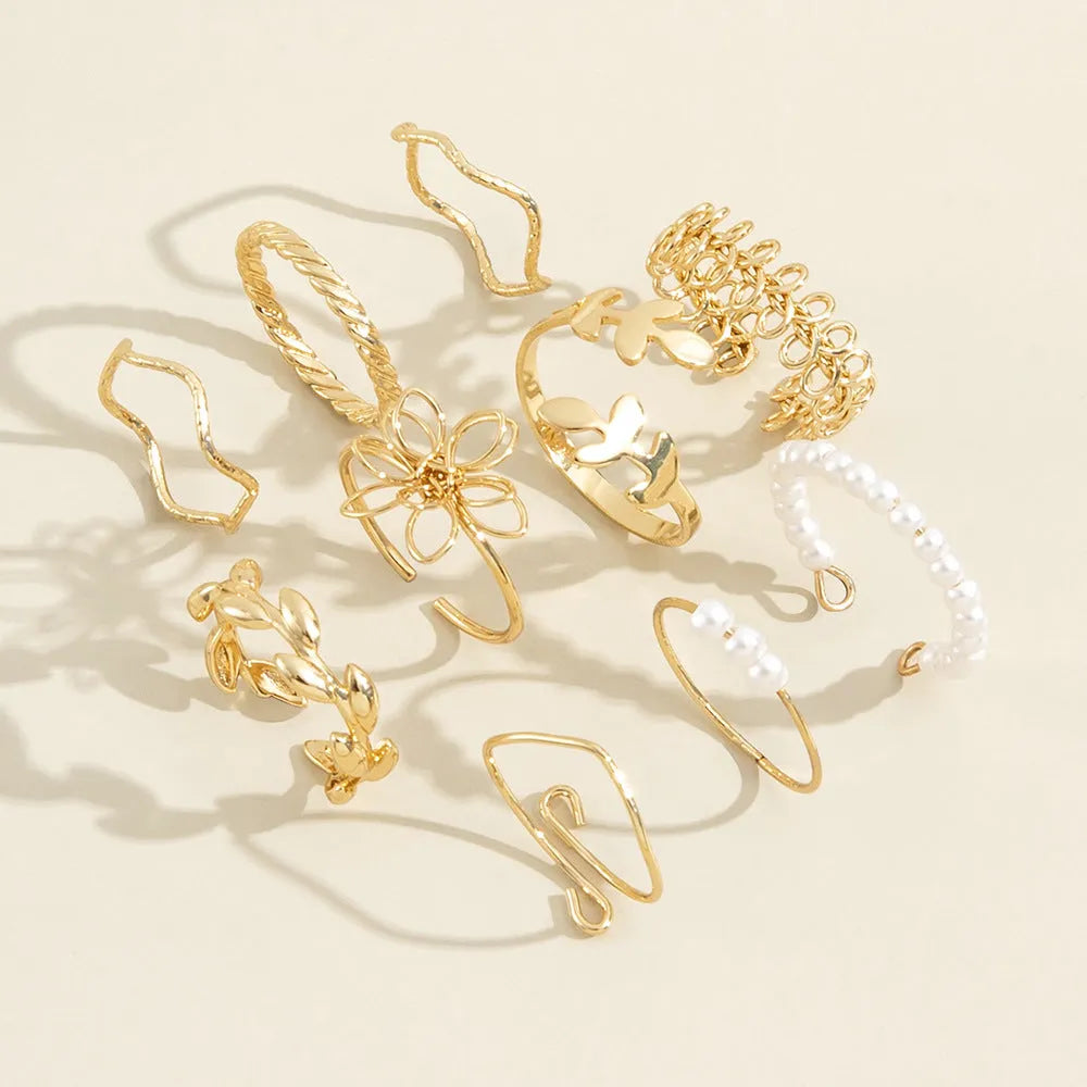 Women's gold openwork flower ring set showing detailed floral cut-out pattern and glossy electroplated finish