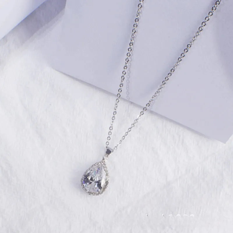 Rose gold geometric water drop pendant necklace on a model, showing adjustable chain and sparkling stone inlay.