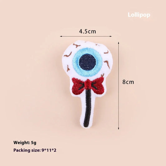 Plush cat teaser wand with candy, eyes, and skull heads on a 40cm string next to a wand handle.