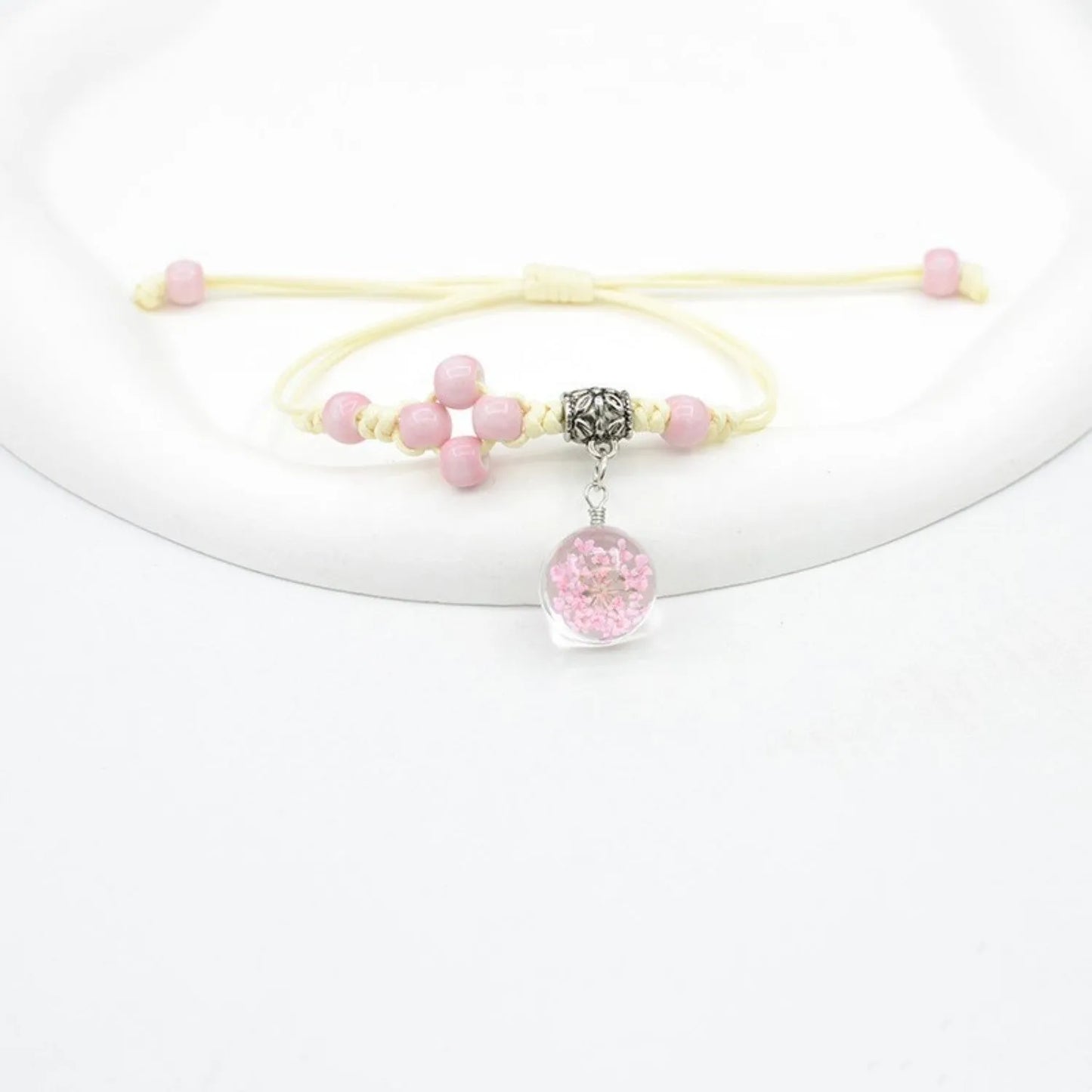 Hand-woven glass bracelet with large 1.4 cm beads containing real dried flowers, shown in blue.
