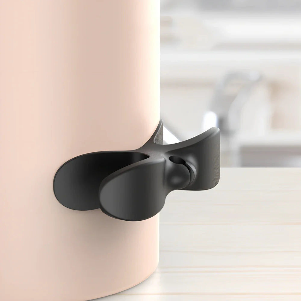 Black TPU cable organizer clips winding appliance cords on kitchen counter, 5cm size, non-marking adhesive for tidy management