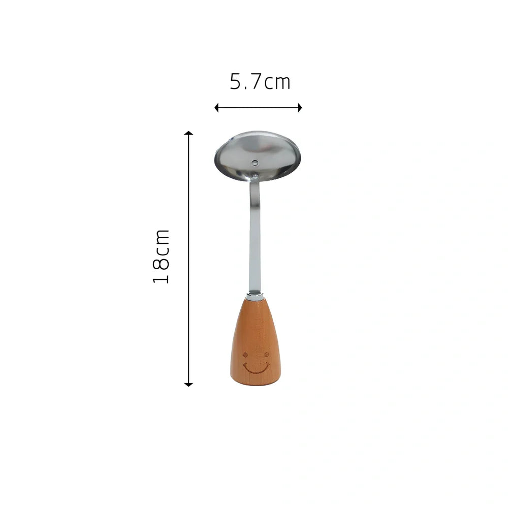 Twelve-piece stainless steel kitchen tools with beech handles and smiley motifs on a kitchen counter