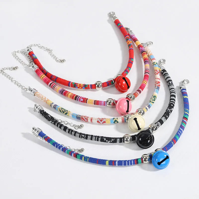 Adjustable coloured ethnic-style pet collar with a small bell, shown in multiple colour options.