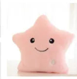 Colourful glowing five-pointed star plush pillow on a dark background.