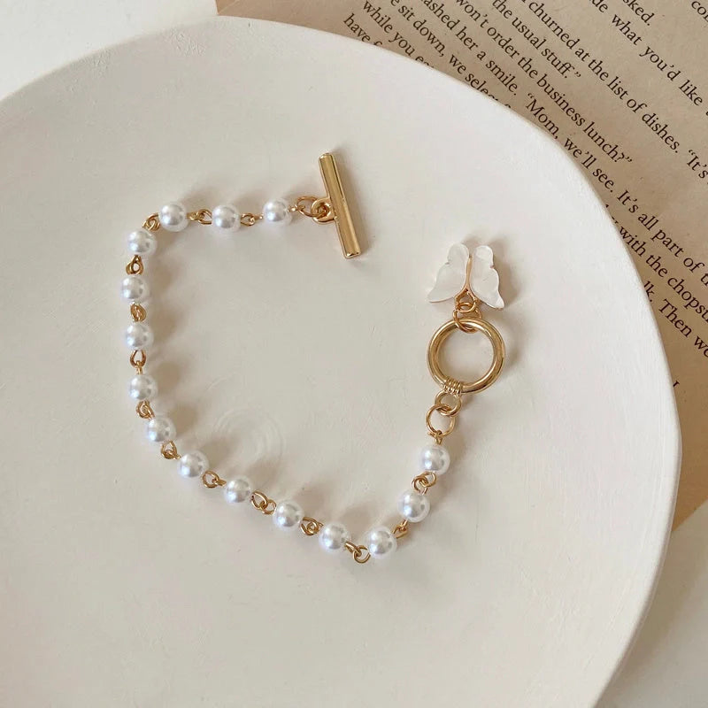 Gold charm bracelet with pearl and butterfly design for women