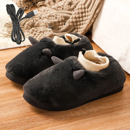 USB heated slippers in grey with a USB cable plugged into a power bank, showing the enclosed velvet design.