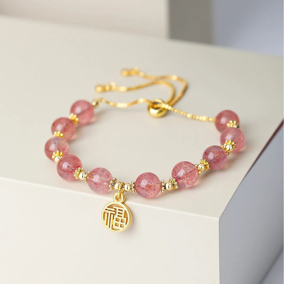 Strawberry quartz bracelet with gold electroplated metal and engraved fu character geometric jewellery design