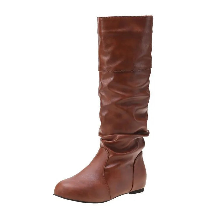 Women's flat slip-on boots in black with round toe and high cylinder shaft on a neutral background.