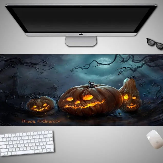 Oversized black mouse pad with Halloween-themed graphic, shown on a wooden desk with keyboard and gaming mouse.
