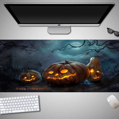 Oversized black mouse pad with Halloween-themed graphic, shown on a wooden desk with keyboard and gaming mouse.