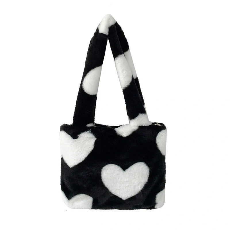 Soft, plush heart-shaped handbag in various vibrant colors with a magnetic closure and interior phone compartment