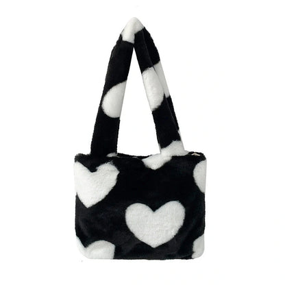 Soft, plush heart-shaped handbag in various vibrant colors with a magnetic closure and interior phone compartment