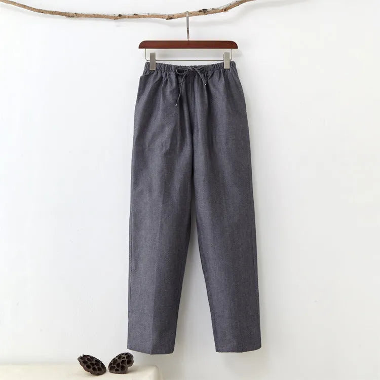 Men's beige pure cotton casual trousers with a drawstring waist on a mid-grey background.