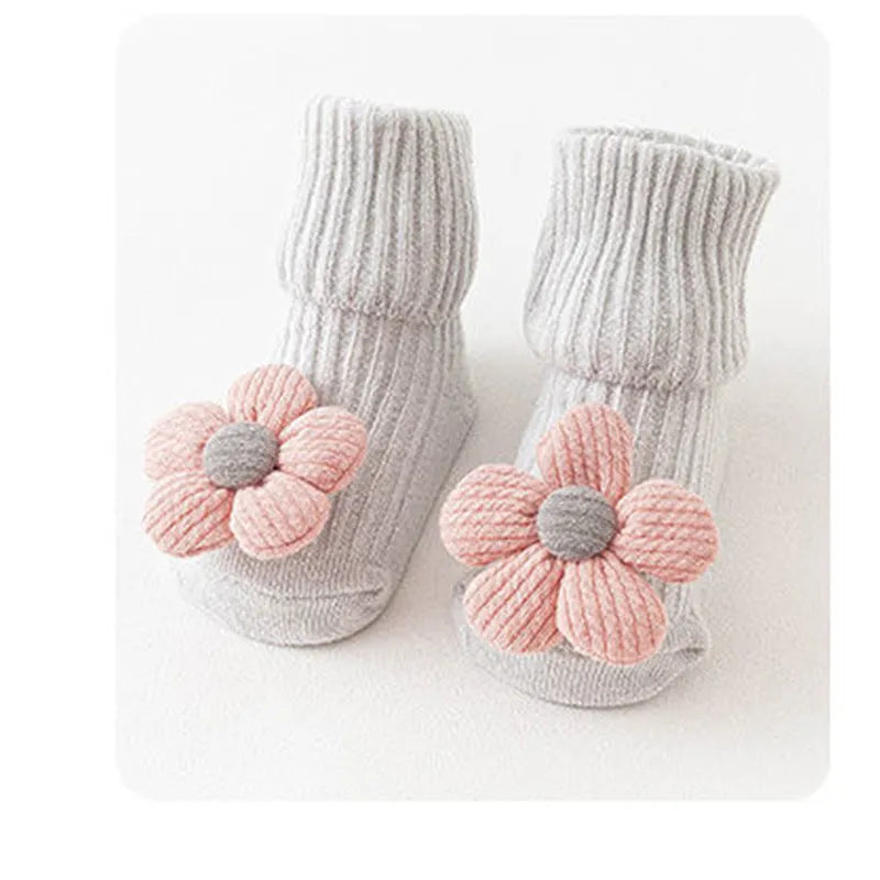 Cotton baby floor socks in assorted colours and patterns including bows, stars, and animal designs.