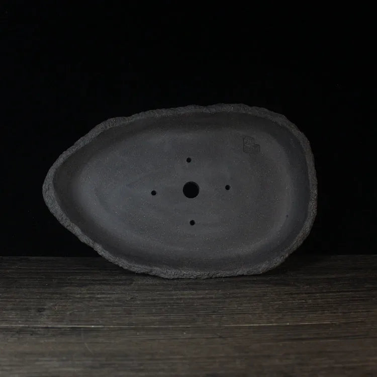 Handmade purple clay flower pot with unique shape showing natural ceramic texture
