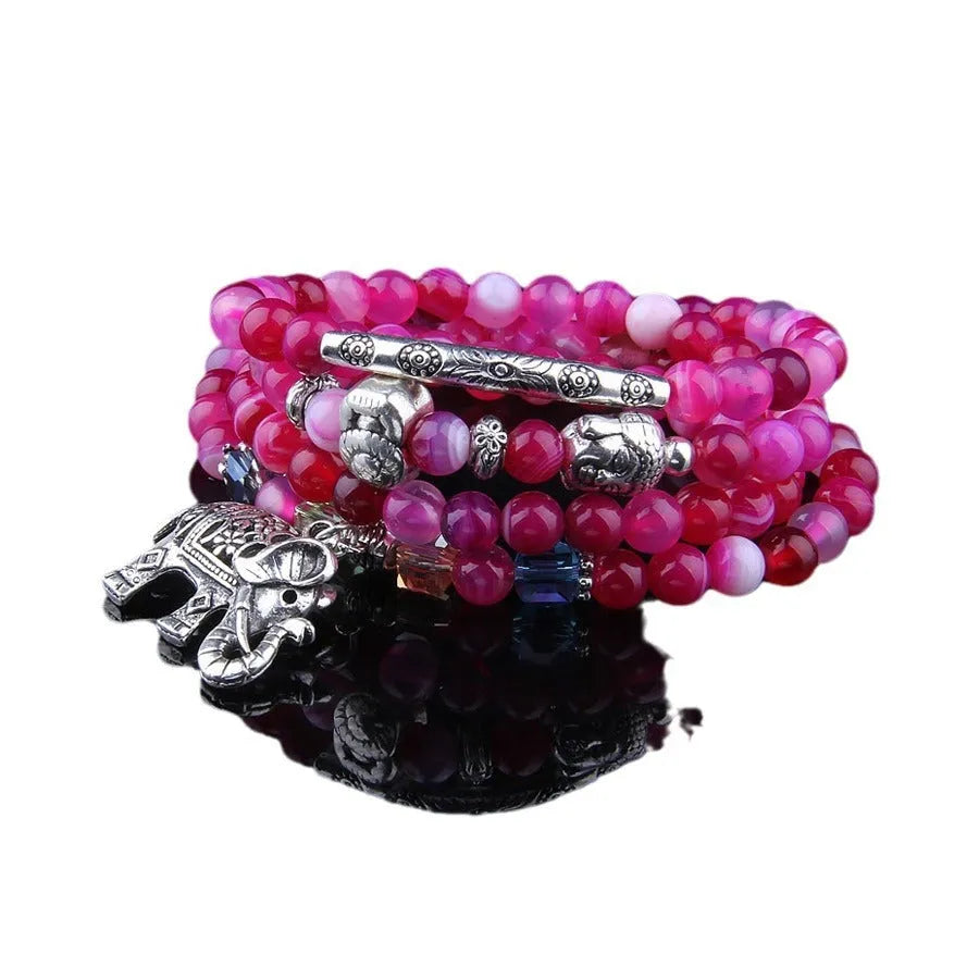 Multi-layer agate amulet bracelet with 6mm beads in blue elephant pattern on a wrist.