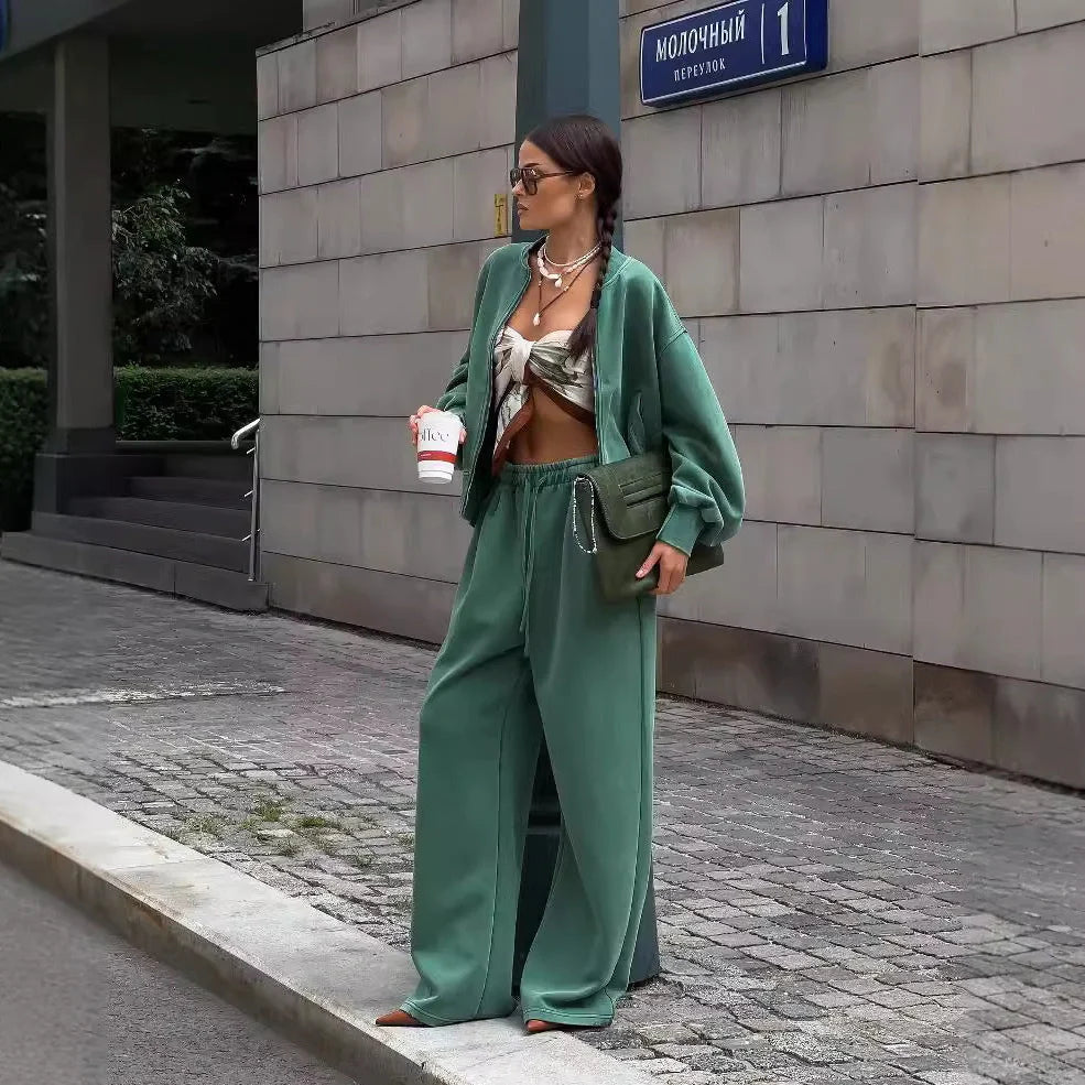 Green women's thermal sweater with front zipper and stand collar, paired with matching trousers