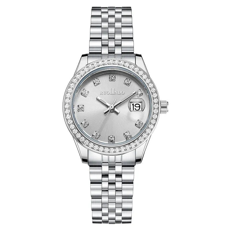 Women's silver alloy calendar watch with quartz movement and stainless steel buckle on wrist.