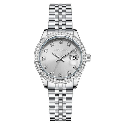 Women's silver alloy calendar watch with quartz movement and stainless steel buckle on wrist.