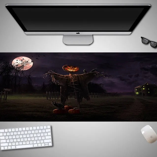 Oversized black Halloween-themed mouse pad with graphic design on a desk with keyboard and mouse